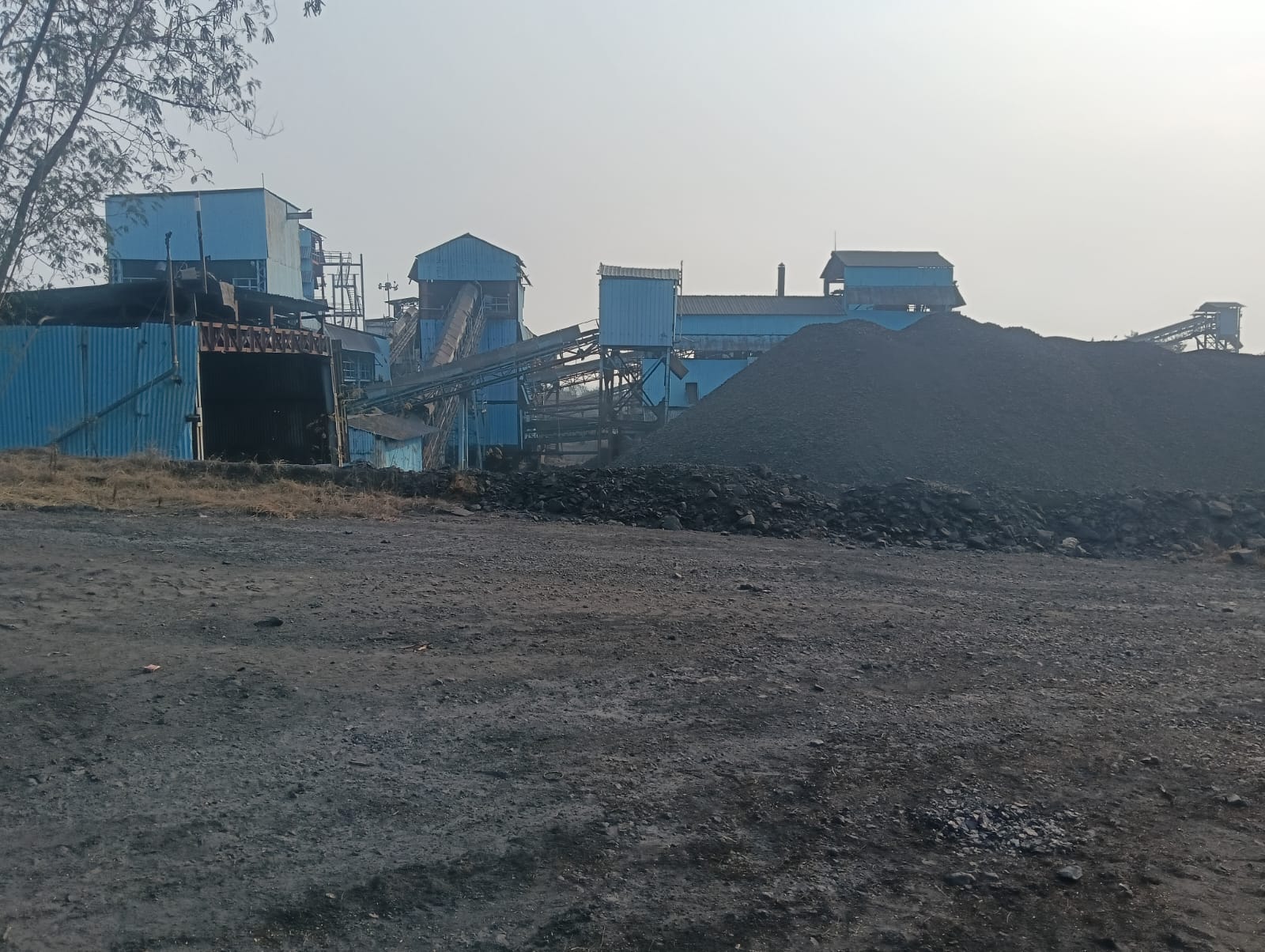 Coal heap with heavy machinery operating at washery site, Nimbala